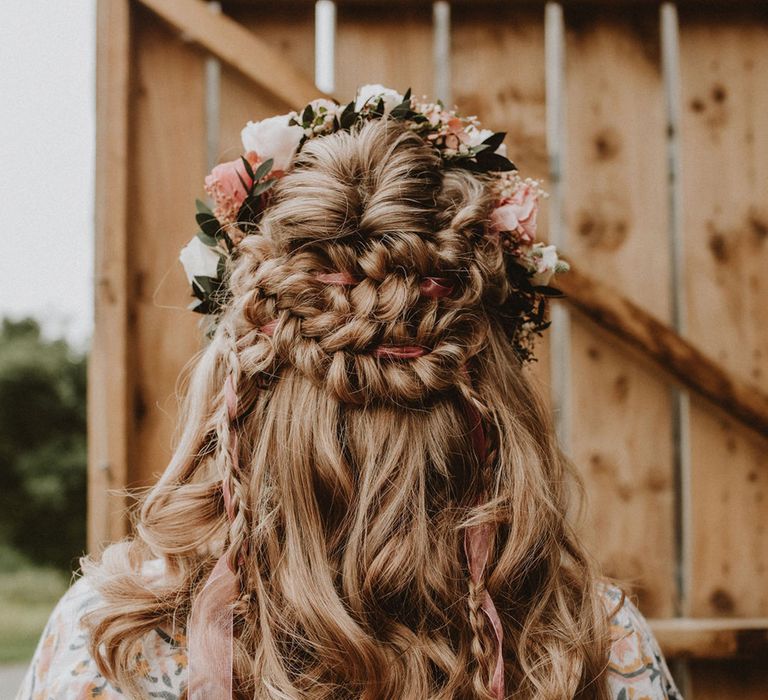 Medieval style hair look with braids and pink ribbon topped with a pink and white flower crown