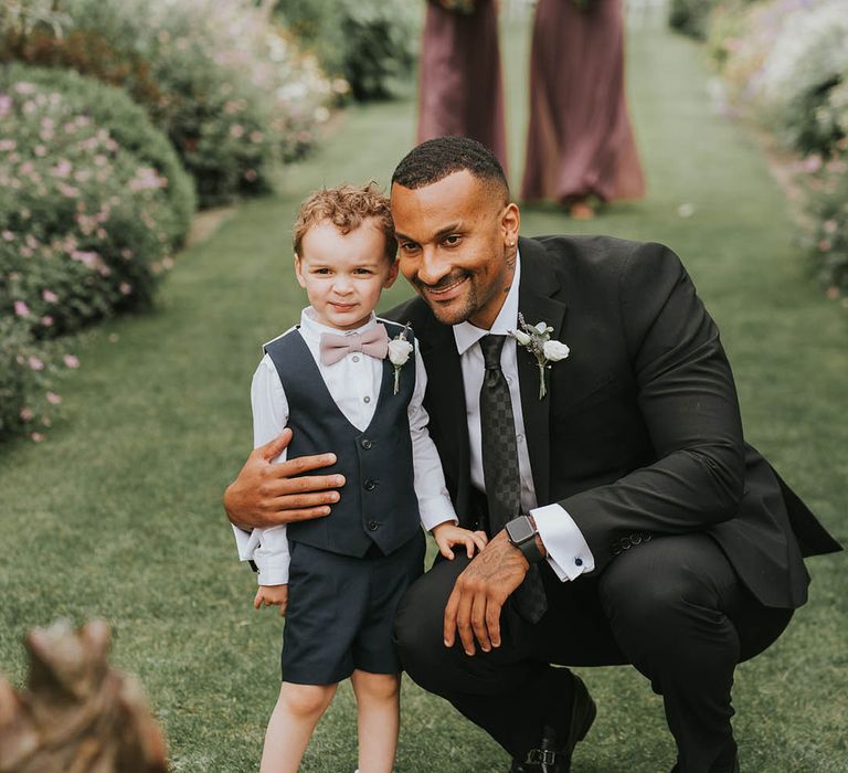 Young page boy and wedding guest grab a photo together