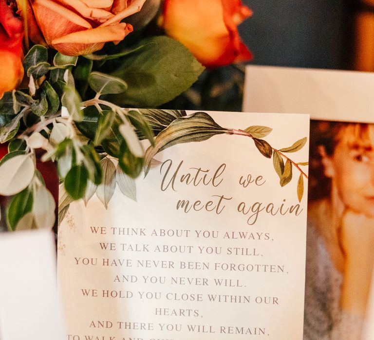 Table with photos of passed family members with special sign 