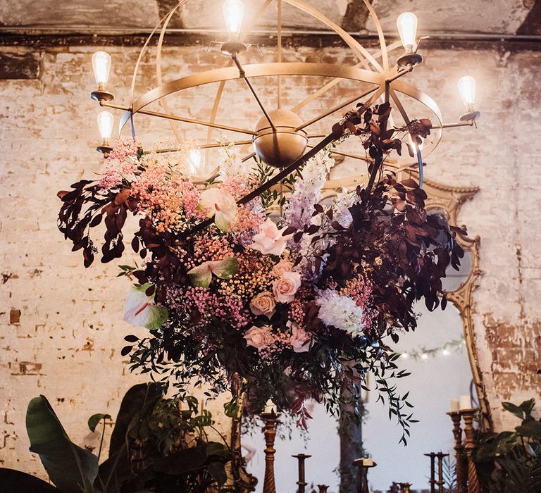 Pink and purple roses, anthuriums, gypsophila and leaves decorate the wedding lighting