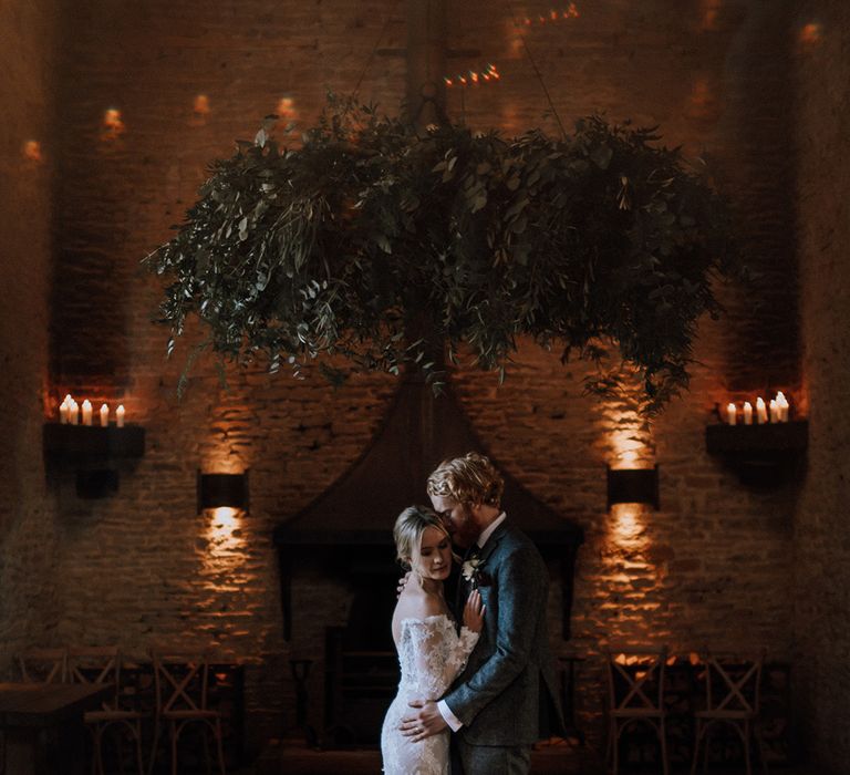 Bride and groom embrace intimately at their rustic wedding 