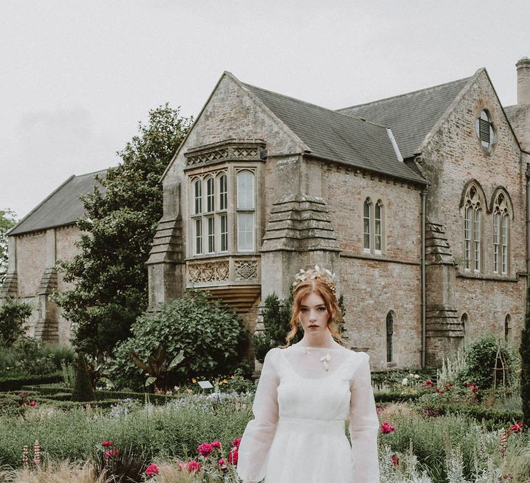 Bride with wearing matching gold leaf headpiece, necklace and cuff with a two-layer wedding dress