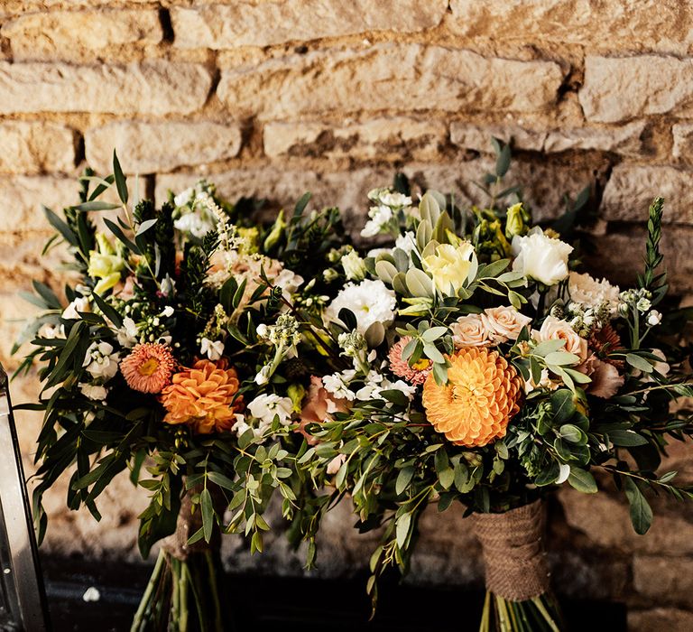 Orange and white dahlias and roses in the bridal bouquets 