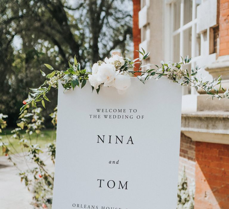 White wedding signage on wooden easel complete with floral decor 