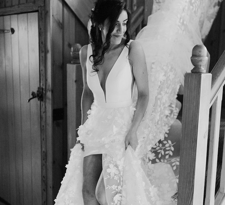 Bride in traditional white wedding dress with front slit wearing a floral applique wedding dress with butterfly hair pins 