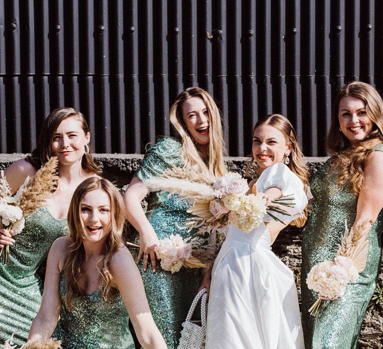 Stunning green sequin midi bridesmaid dresses with the bride in puff sleeve wedding dress with pampas grass bouquets 