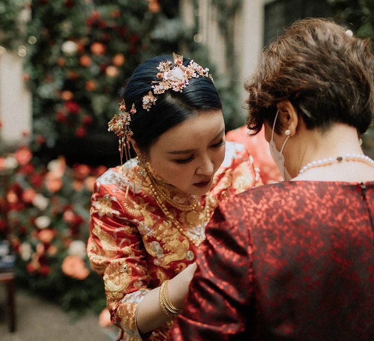 Wedding in Canada with the bride wearing a traditional red and gold Chinese wedding outfit with delicate gold headpiece accessory 