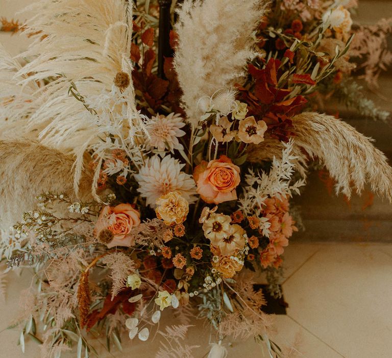 Pampas grass wedding flower arrangement with orange wedding flowers for autumnal theme wedding 