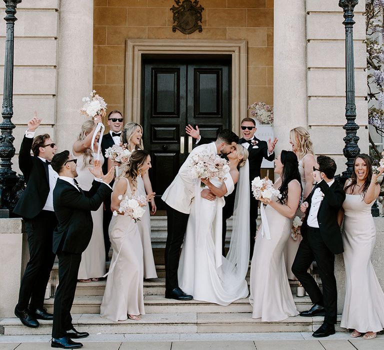 Wedding party with groomsmen in black tie and bridesmaids in pale pink bridesmaid dresses at country house venue 