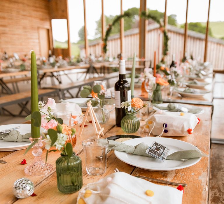 Green theme wedding table setting with pink and green coloured glassware and pink flowers 