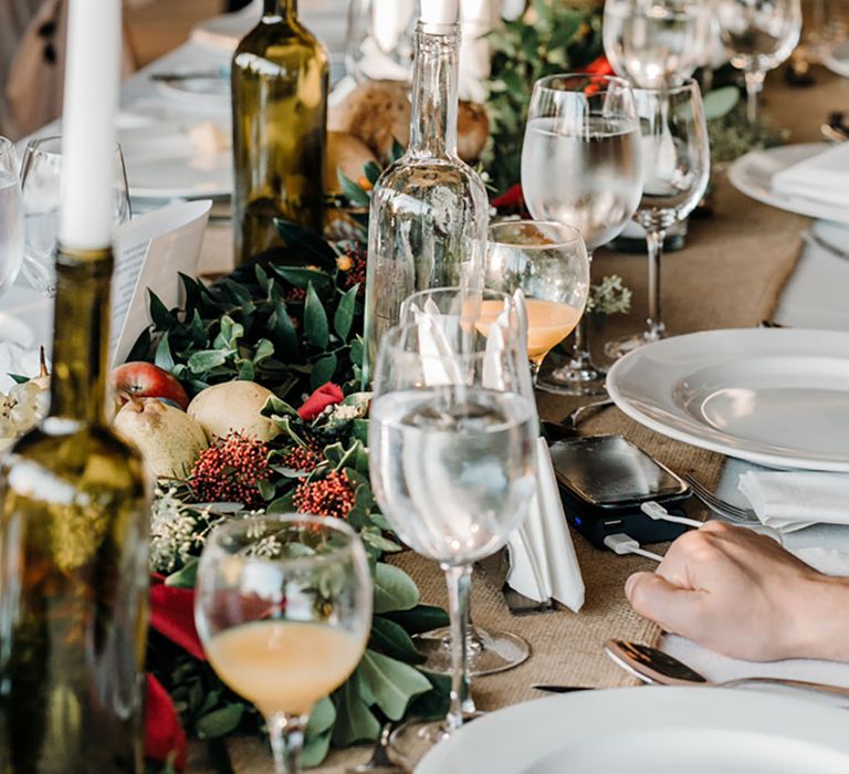 Christmas table decorations with foliage and fruit as table runner for festive wedding 