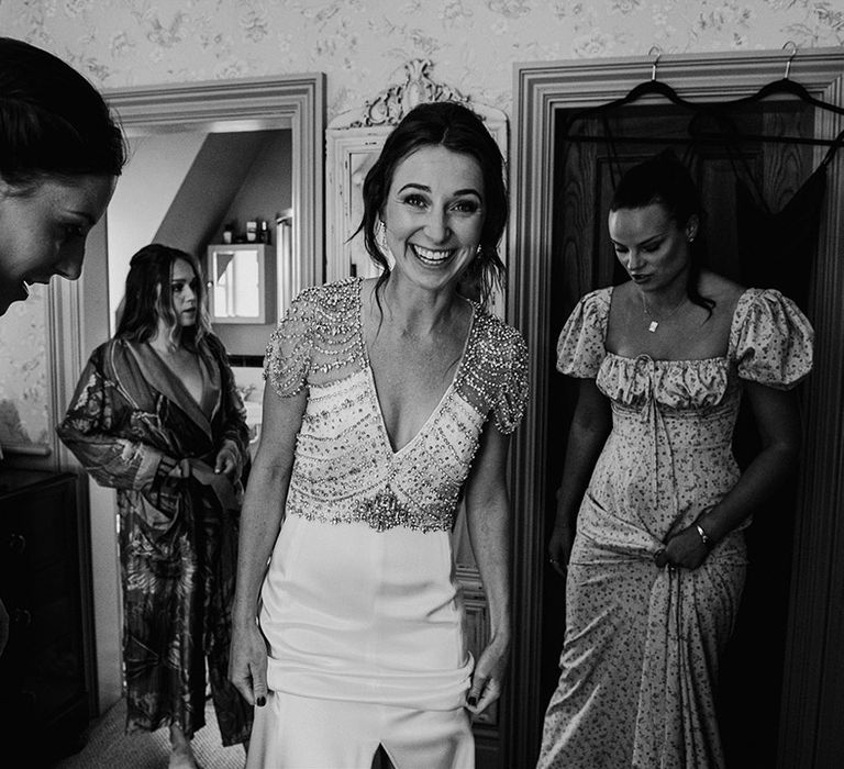 Bride wearing a Jenny Packham sparkly beaded wedding dress getting ready with her bridesmaids 