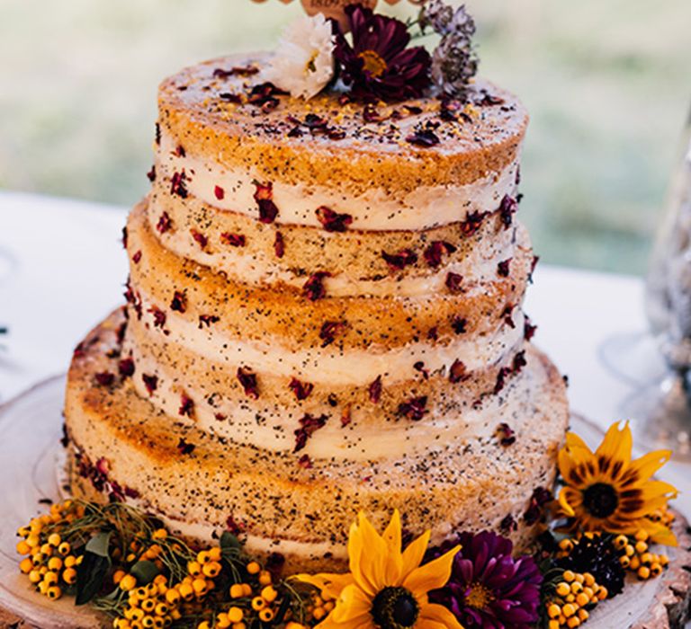 Naked wedding cake decorated with dried rose petals with custom wedding cake topper 