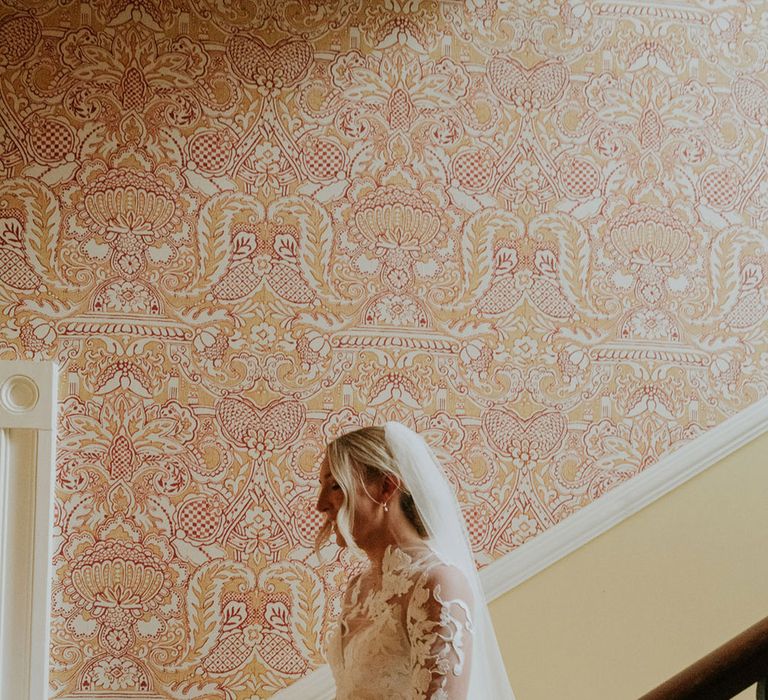 Bride walking down the stairs in a traditional lace wedding dress 