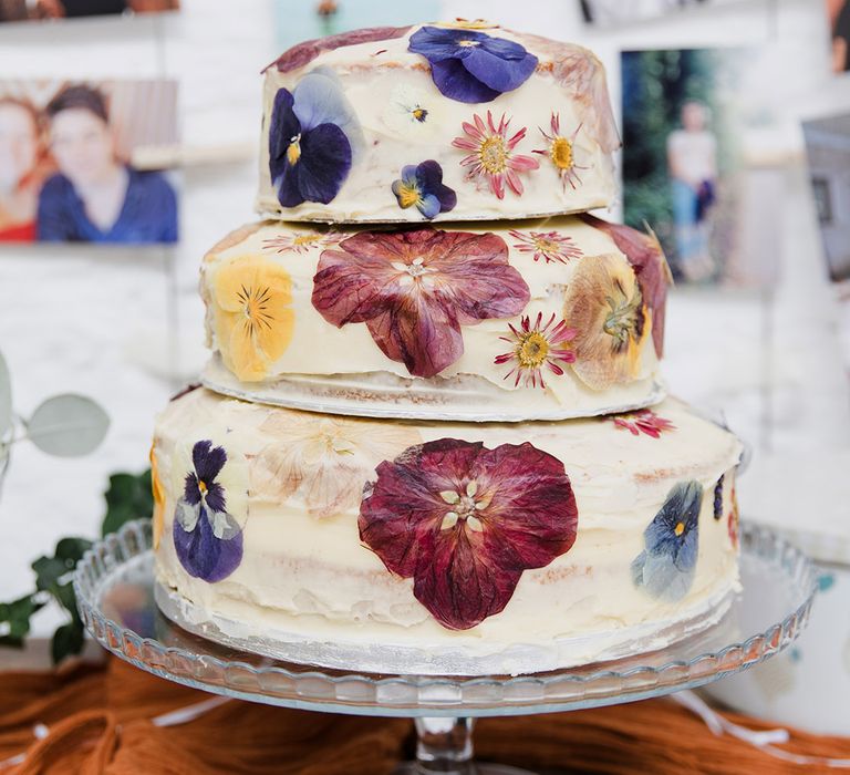 Three tier white iced wedding cake decorated with wildflowers 