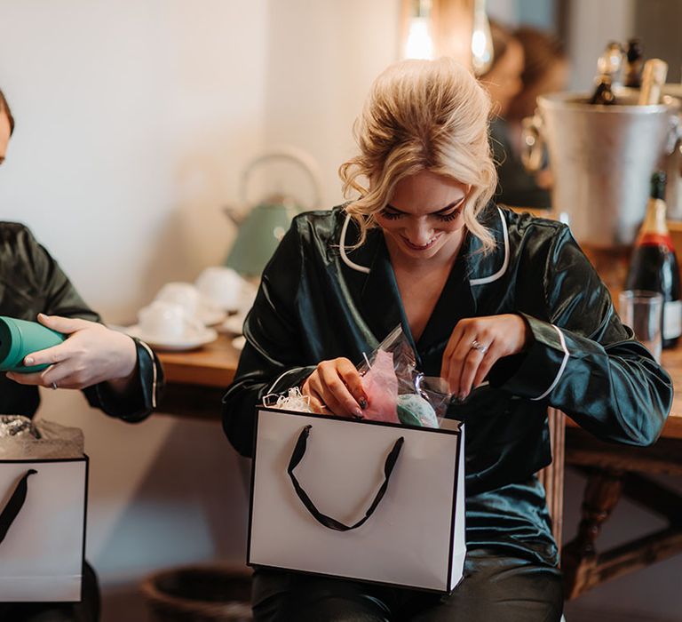 Bridesmaids in their pyjamas opening bridesmaid gifts on the morning of the wedding 