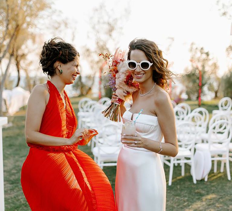 Bride with guest wearing orange dress by Brian Robinson Photography