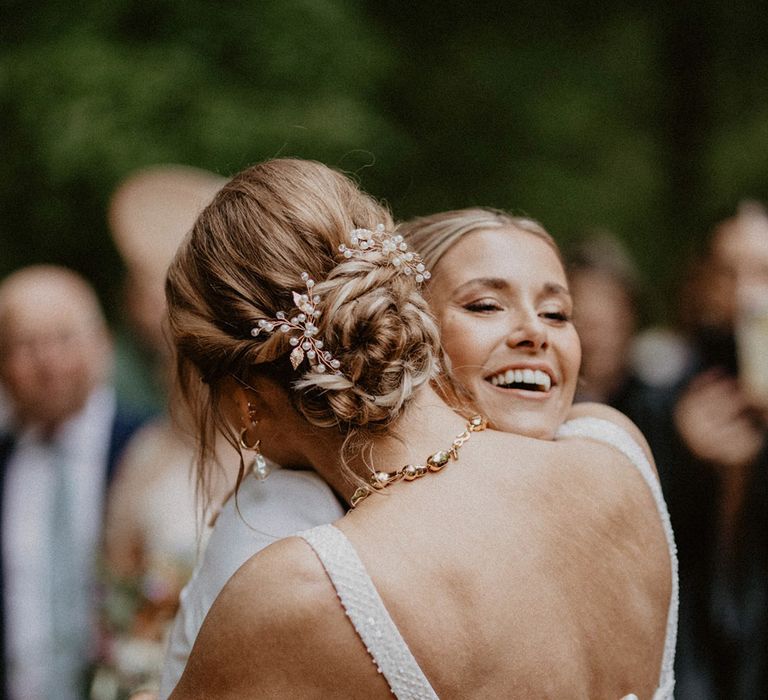 The two brides hug at their lesbian wedding ceremony at Wellington Wood 