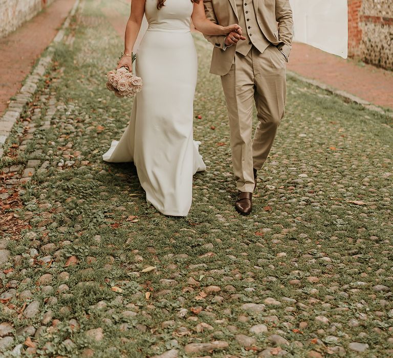 At home wedding for elegant bride and groom as they walk around the local hometown on their wedding day 