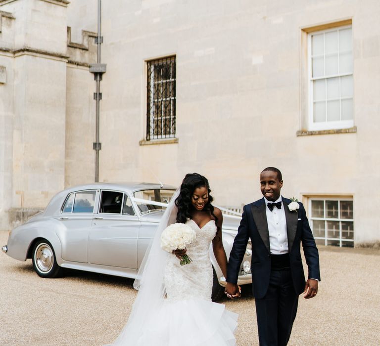 Bride and groom portrait with a vintage wedding car in the background 