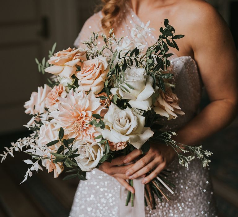 Blush pink and peach bridal bouquet with dahlias, roses and foliage 