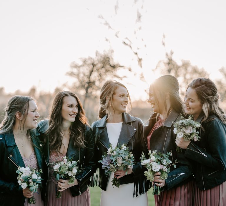 Bridal party in leather jackets holding succulent bouquets 