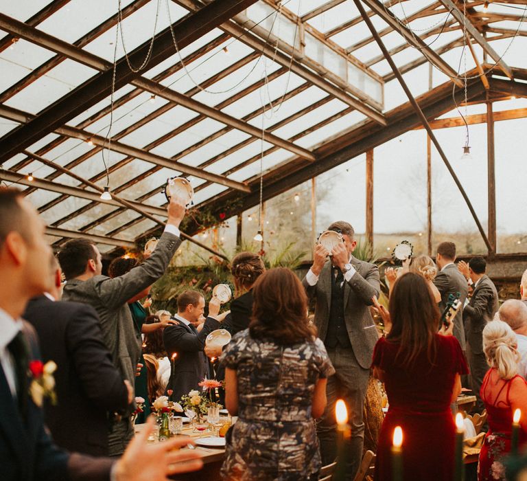 Wedding guests having fun with their tambourine wedding favours 