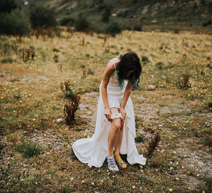 Bride puts on garter in the Lake District before ceremony