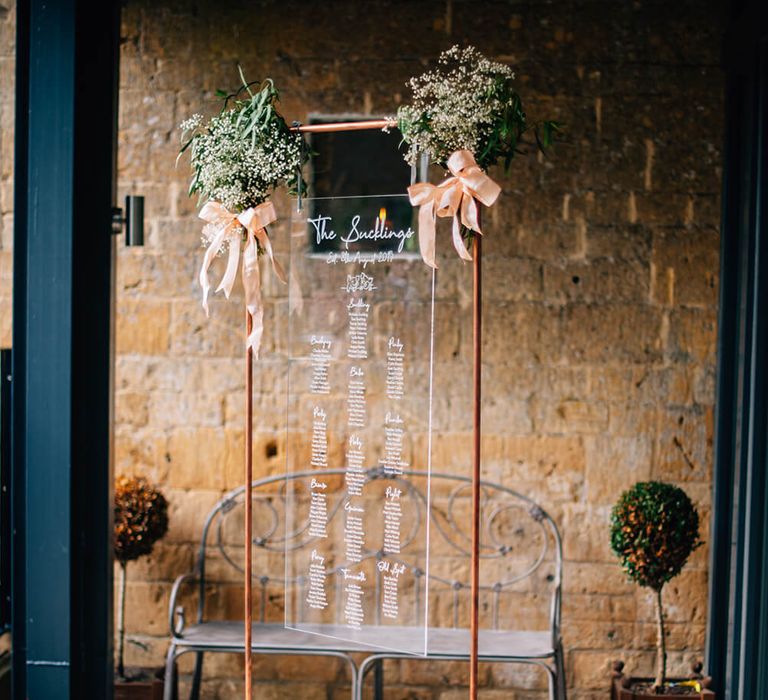 Acrylic seating plan with rose gold stand and pink roses with lanterns and flowers