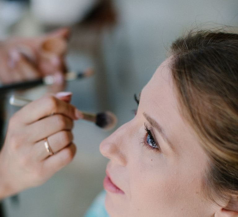 The bride having her make up done for her destination wedding in Greece