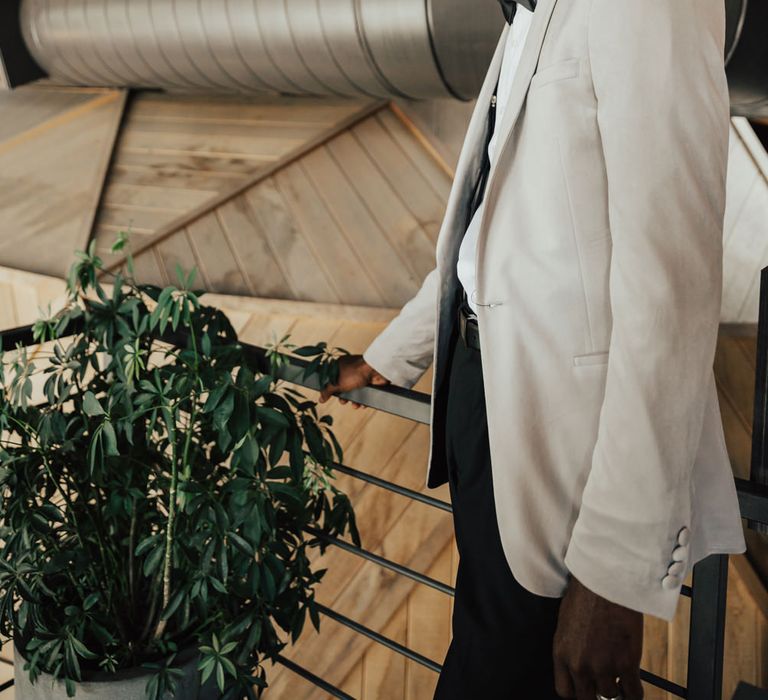 Stylish Black groom in a grey blazer with bow tie for edgy elopement 