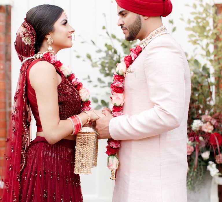 Bride & groom wear floral garlands