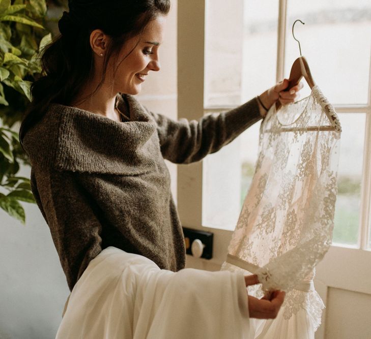 Bride holding up a lace wedding dress