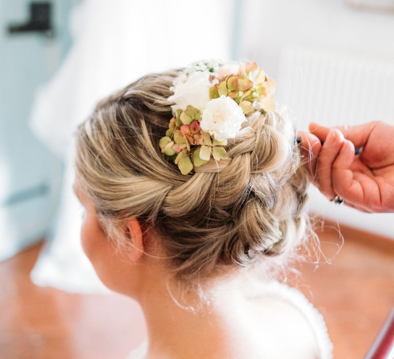 The bride wore a plaited up-do with delicate white and green flowers in her hair