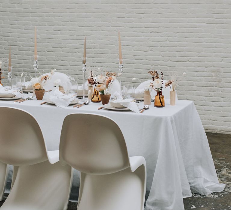 Modern curved seating with traditional tapered candle tablescape details for all white wedding