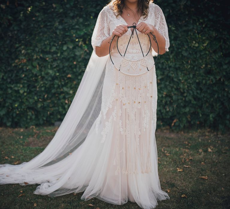 Bride wears boho chic Enzoani wedding gown and floor length veil