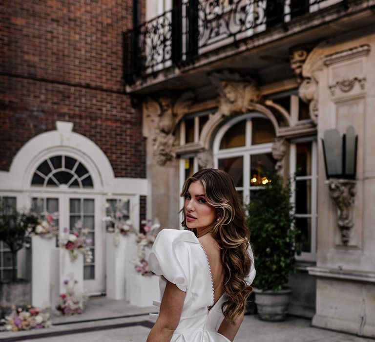 Bride in a Love In Lace Bridal gown with puff sleeves and long wavy hair 