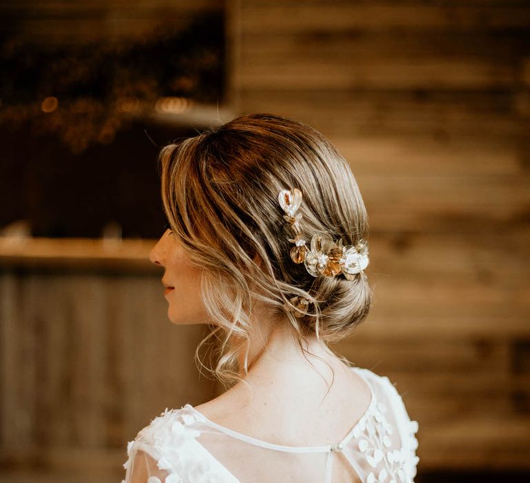 Bride with low up-do hairstyle and floral hair accessory from Garter & Veil