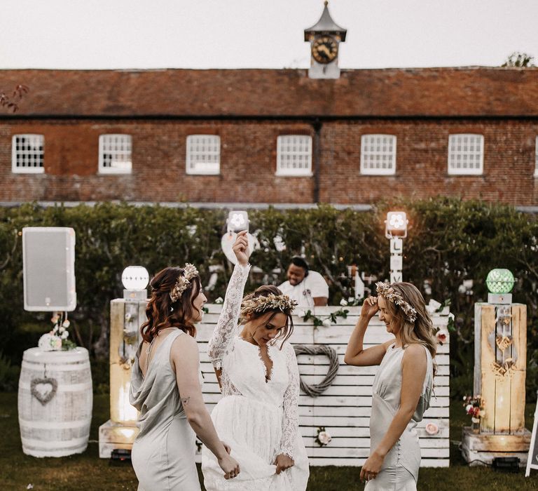 Bride and bridesmaids dancing in front of the wooden Boombox UK DJ booth