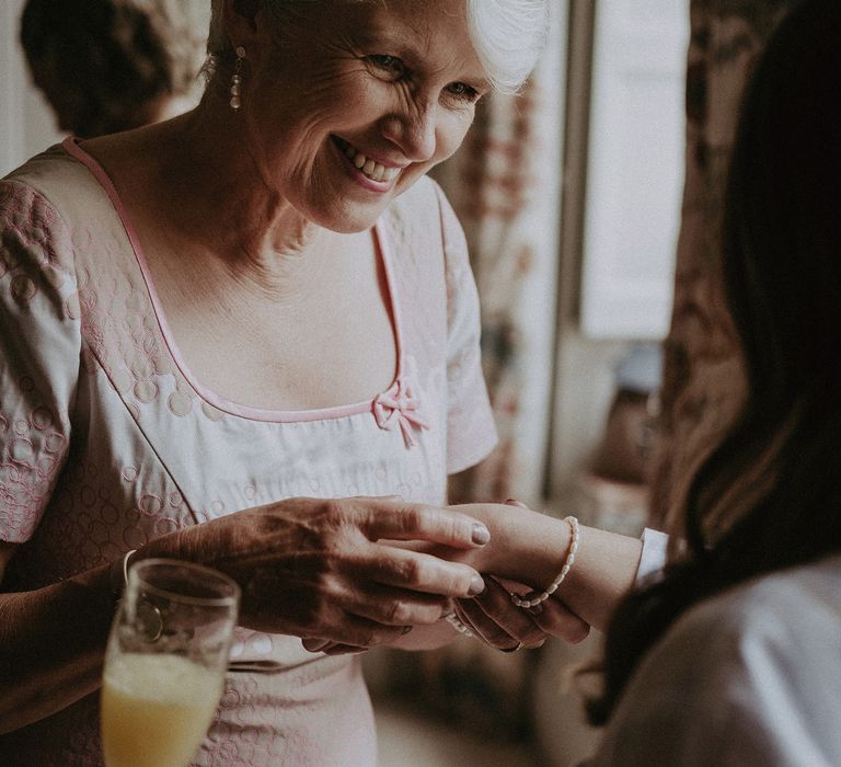 Mother of the bride on the morning of wedding admires brides bracelet