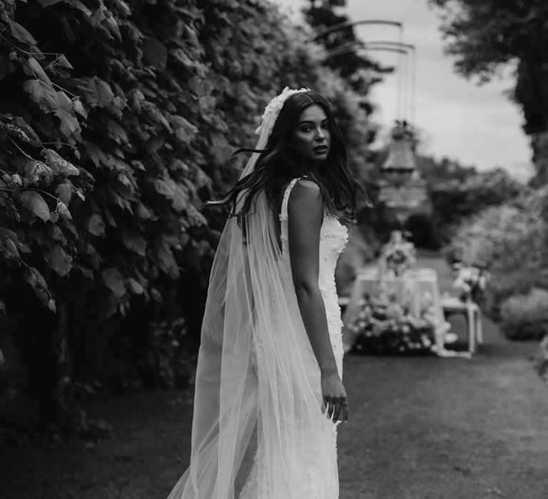 Black and white portrait of a bride in an appliqué wedding dress and matching veil from the new Nova Suzanne Neville bridal collection 2022