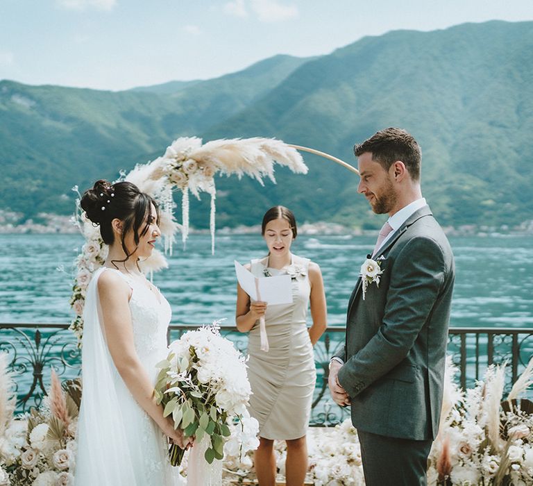 Bride & groom during wedding ceremony in front of Floral installation complete with pampas grass and neutral tones