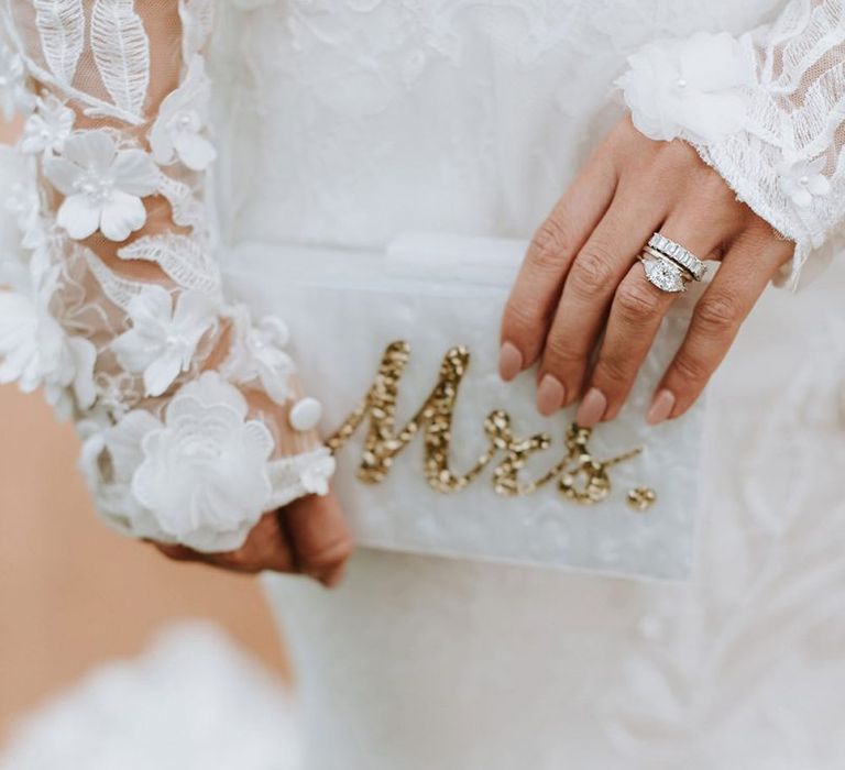 Bride holds Mrs embellished purse with engagement ring and wedding band | Georgina Harrison Photography