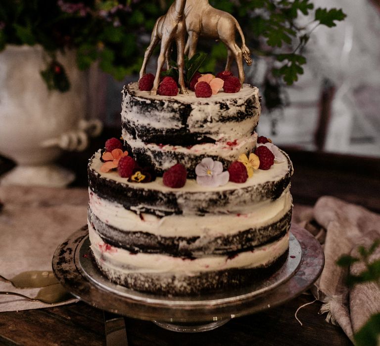 Naked chocolate wedding cake with gold giraffe cake toppers 