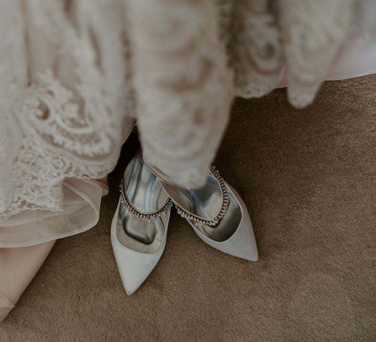 Pointed mint green heels with silver beaded strap next to homemade lace wedding dress for DIY garden wedding