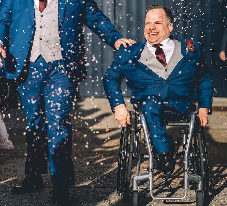 Confetti moment for grooms in matching blue suits at The Chainstore Trinity Buoy Wharf wedding venue in London