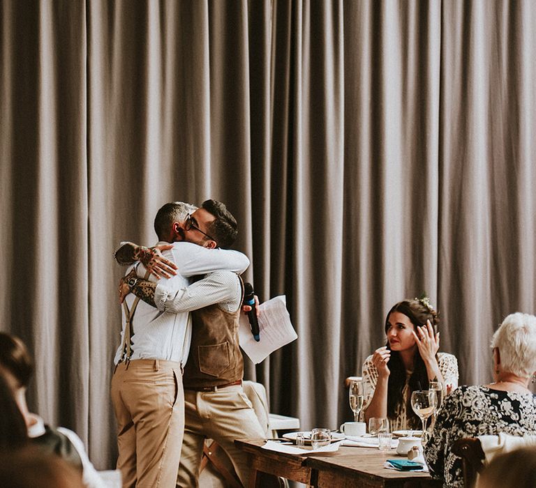 Groom hugs wedding guest on the day of his wedding