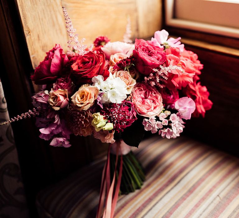 Red, pink and white mixed rose bridal bouquet on window seat