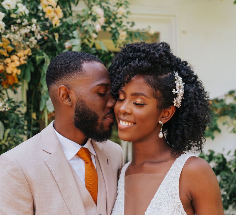 Black Bride in a V neck wedding dress and naturally curly hair with pearl drop earrings