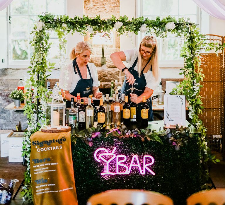 Wedding bar complete with green foliage, pink neon sign and fabric banner